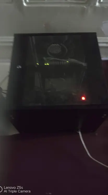  small, enclosed server or network cabinet, likely wall-mounted, taken in a dimly lit room.